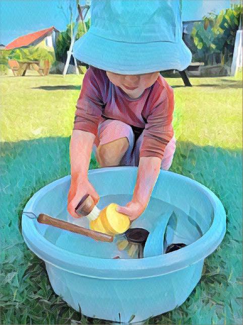 Dagplejebarn der vasker legetøj i naturen, hos Dagplejemor Lykke Stage i Odense S, Højby.